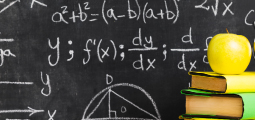 Uma lousa negra escolar clássica inteiramente preenchida com giz branco contendo fórmulas algébricas, equações complexas, gráficos de eixos coordenados, cálculo de derivadas e o desenho geométrico de um semicírculo com um triângulo retângulo inscrito. No canto inferior direito, em primeiro plano, há uma pequena pilha de três livros escolares com capas em tons de amarelo e verde, encimada por uma maçã fresca de cor amarelo-esverdeada brilhante.
